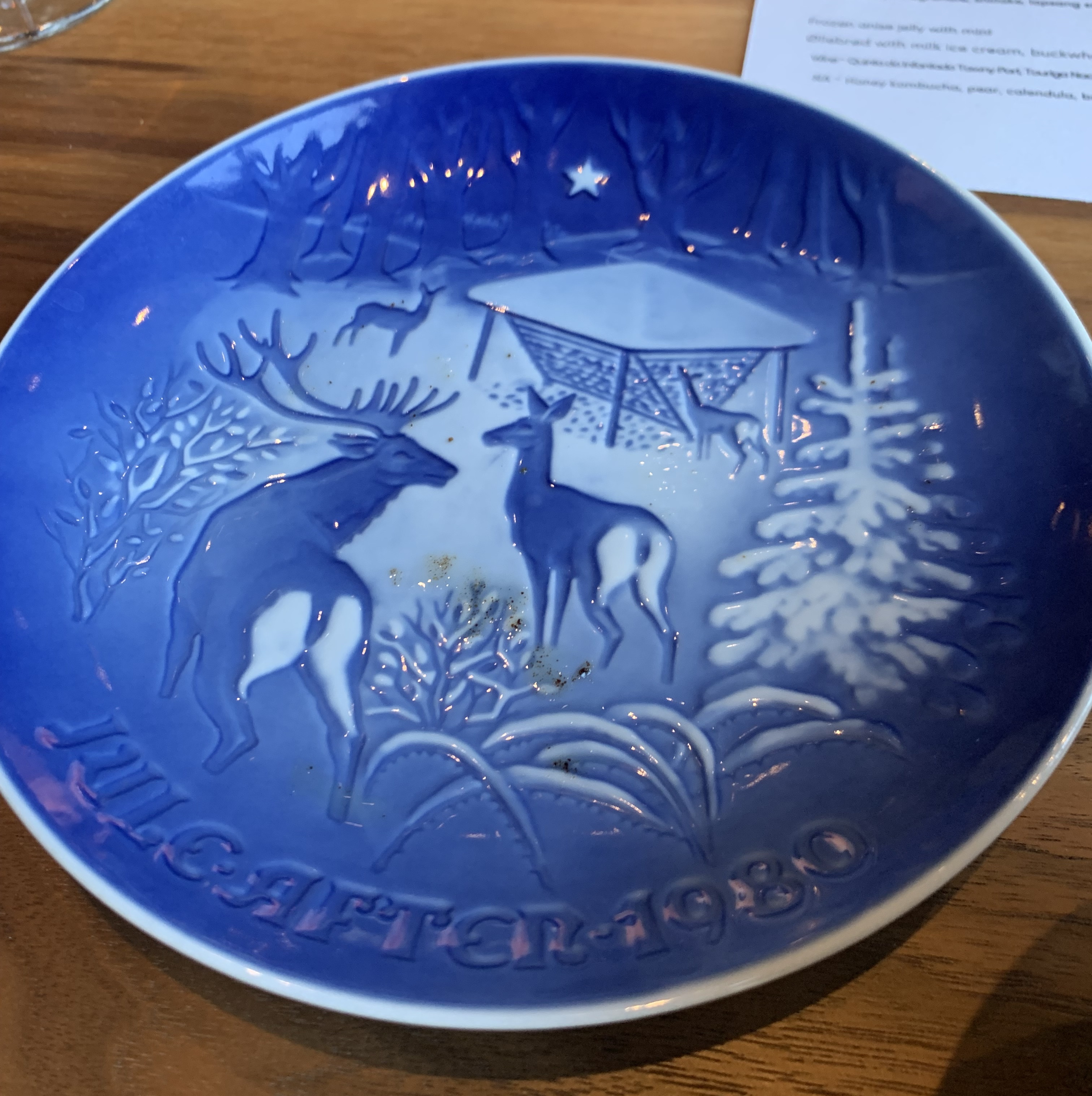 Slightly dirty blue plate depicting a winter scene on the edge of the forest, with two deer showing their voluminous asses to you.