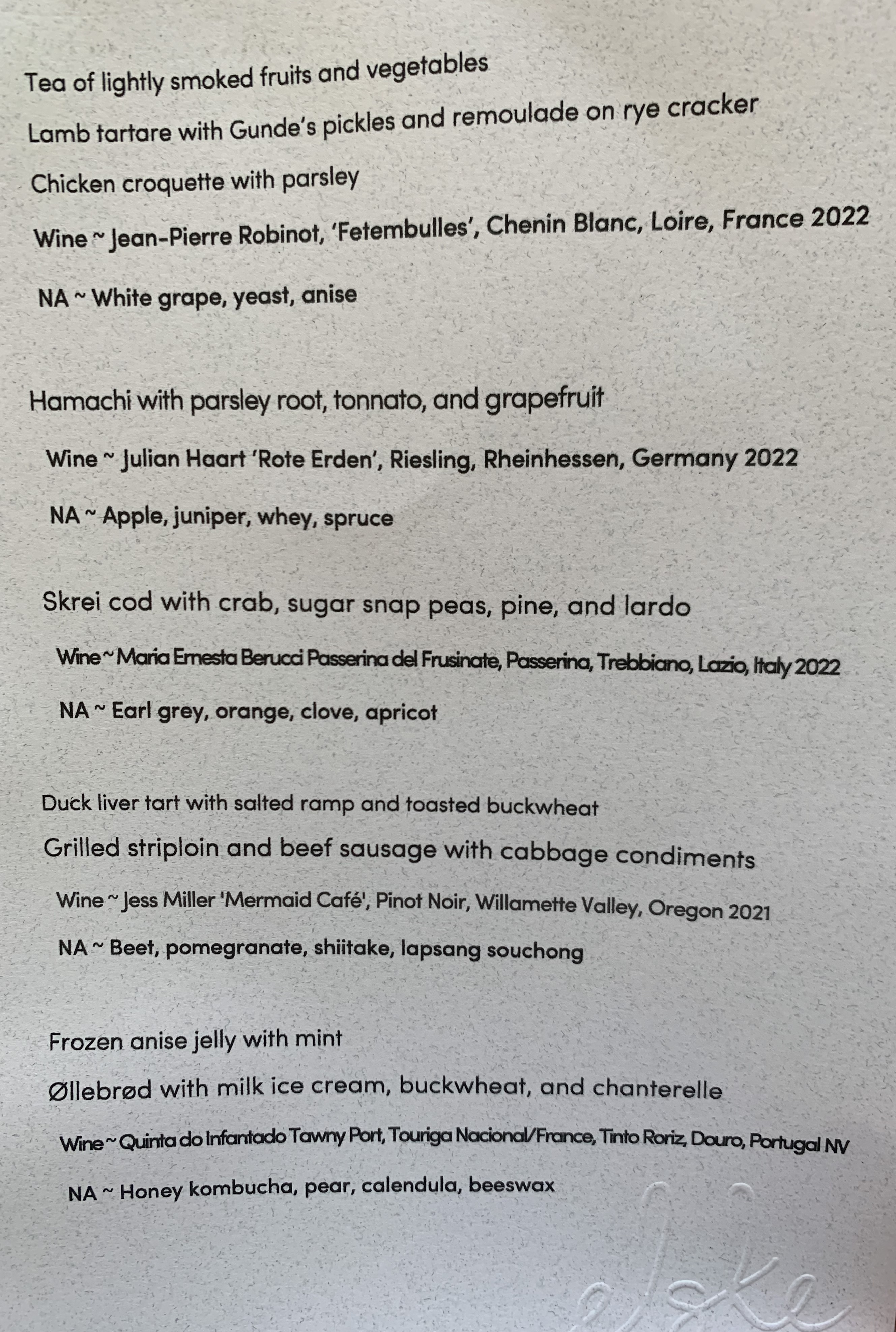 A menu listing all the dishes and their accompanying wines or non-alcoholic beverages.