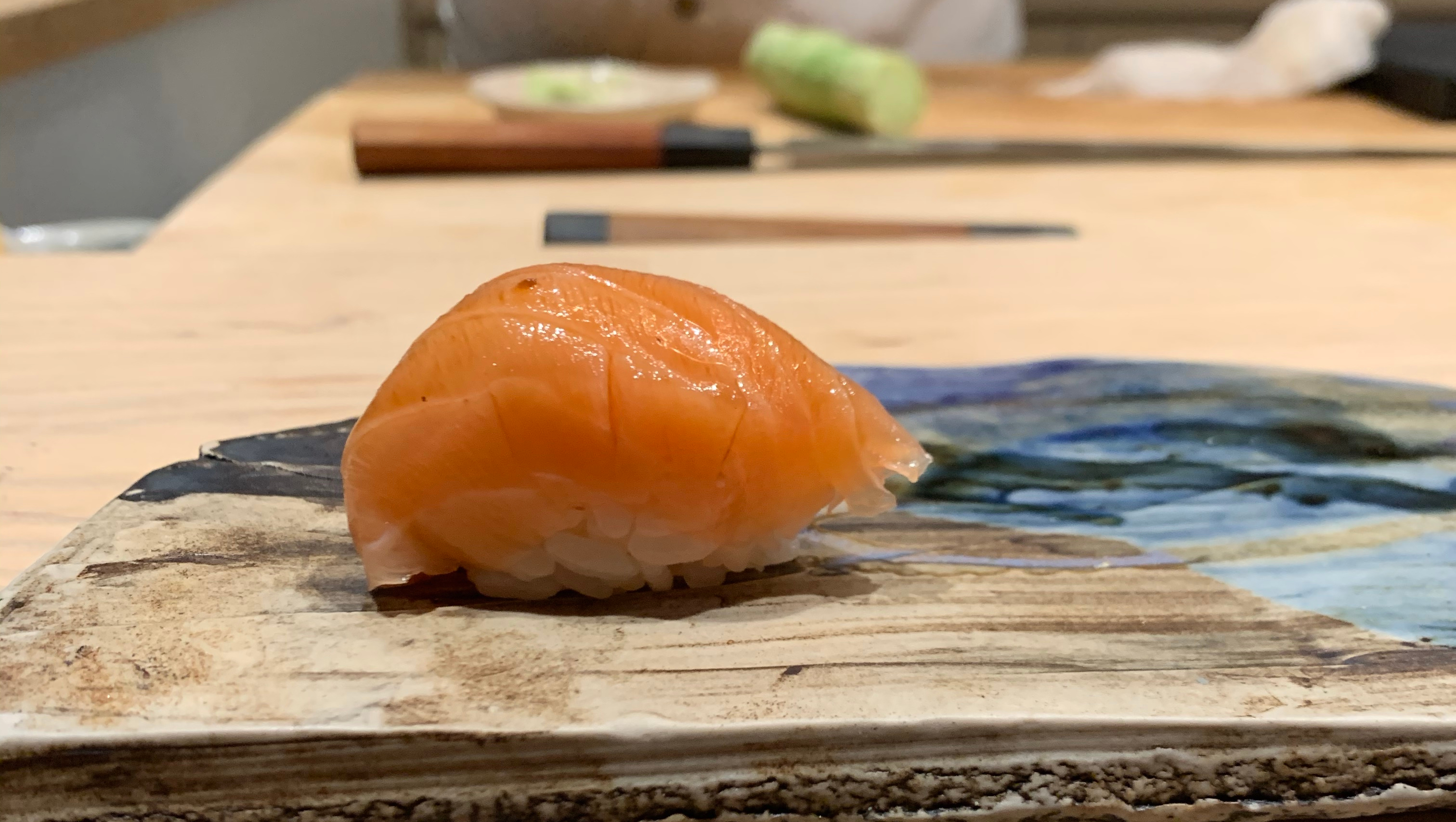One piece of nigiri sushi, with an orange fish