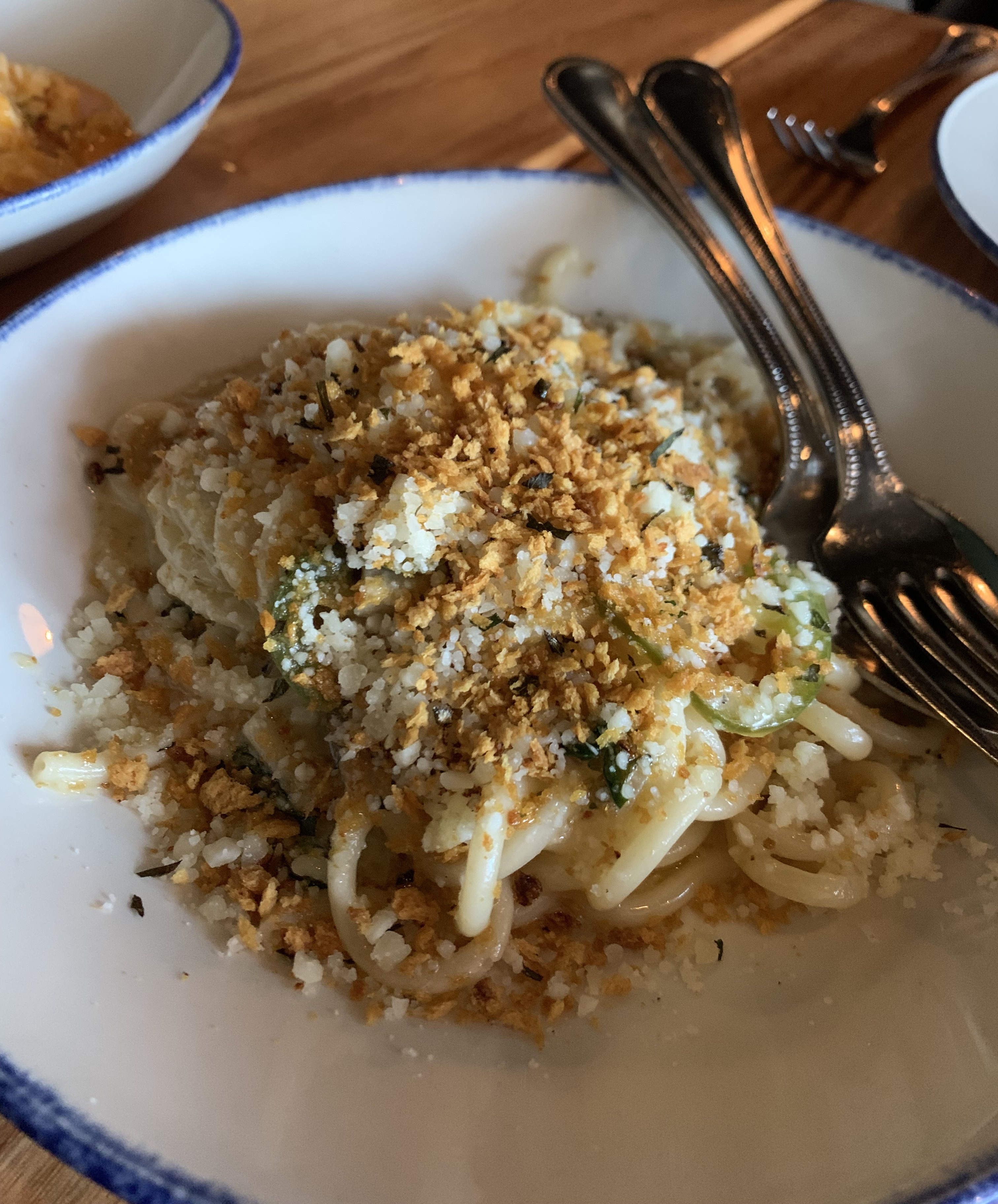 Plate of thick pasta noodles covered in crispy bits