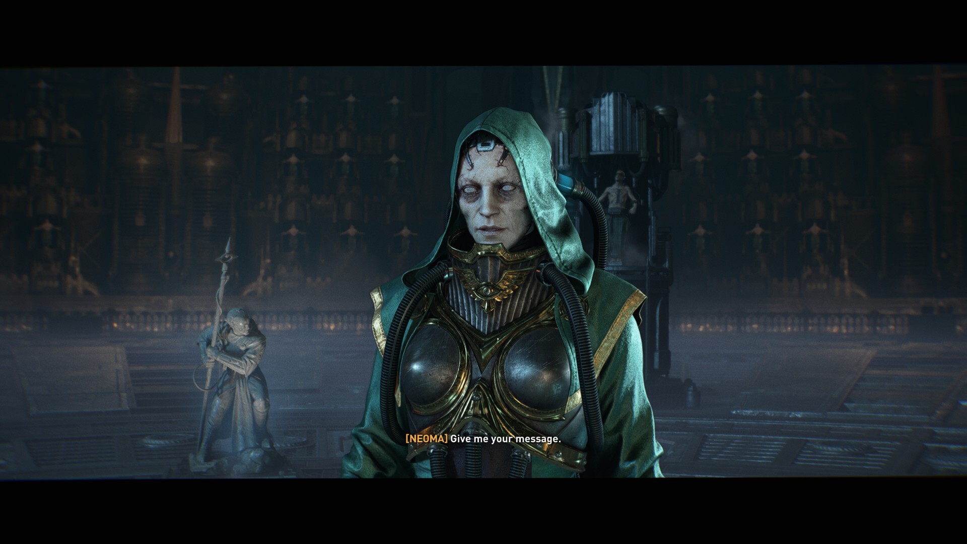 A woman with empty eye sockets, wearing a green robe. She is very pale and has traces of psi-amplifiers integrated into the edges of her face. Behind her is a psyker restrained in a tower.