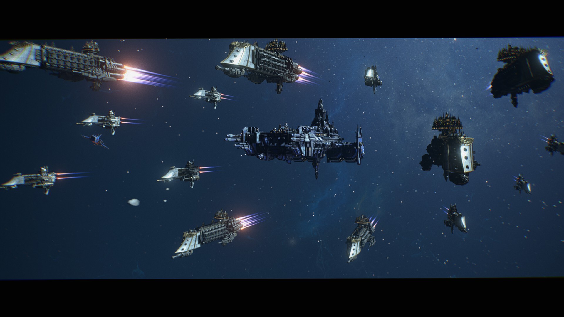 Several spaceships engage their engines and fly in formation towards the viewer. Most of the ships are long, with their central segment decorated ornately. They have an armoured prow that tapers, good for ramming. One of the ships is wider and does not feature the armoured prow.