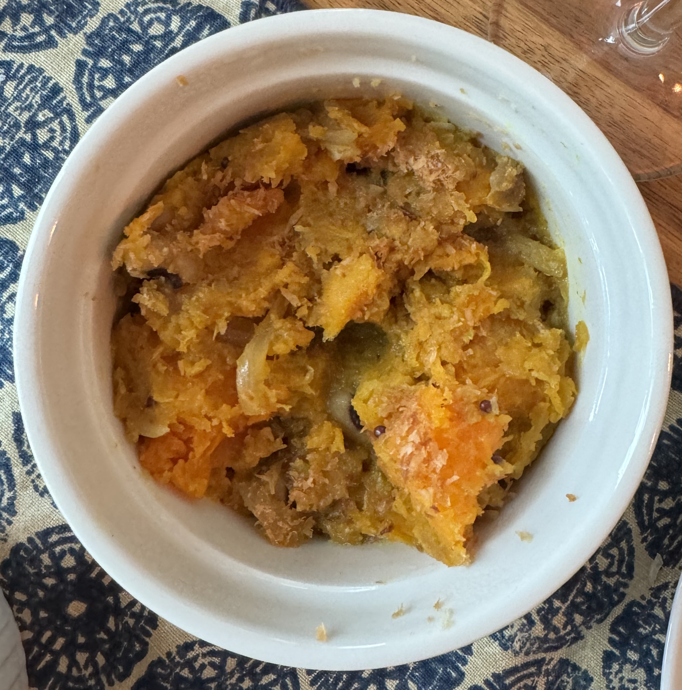 Roasted squash that has broken down into a thick paste. Chunks of squash are still visible, but it's half-way to being a puree. Spices and onions are visible in the mix.