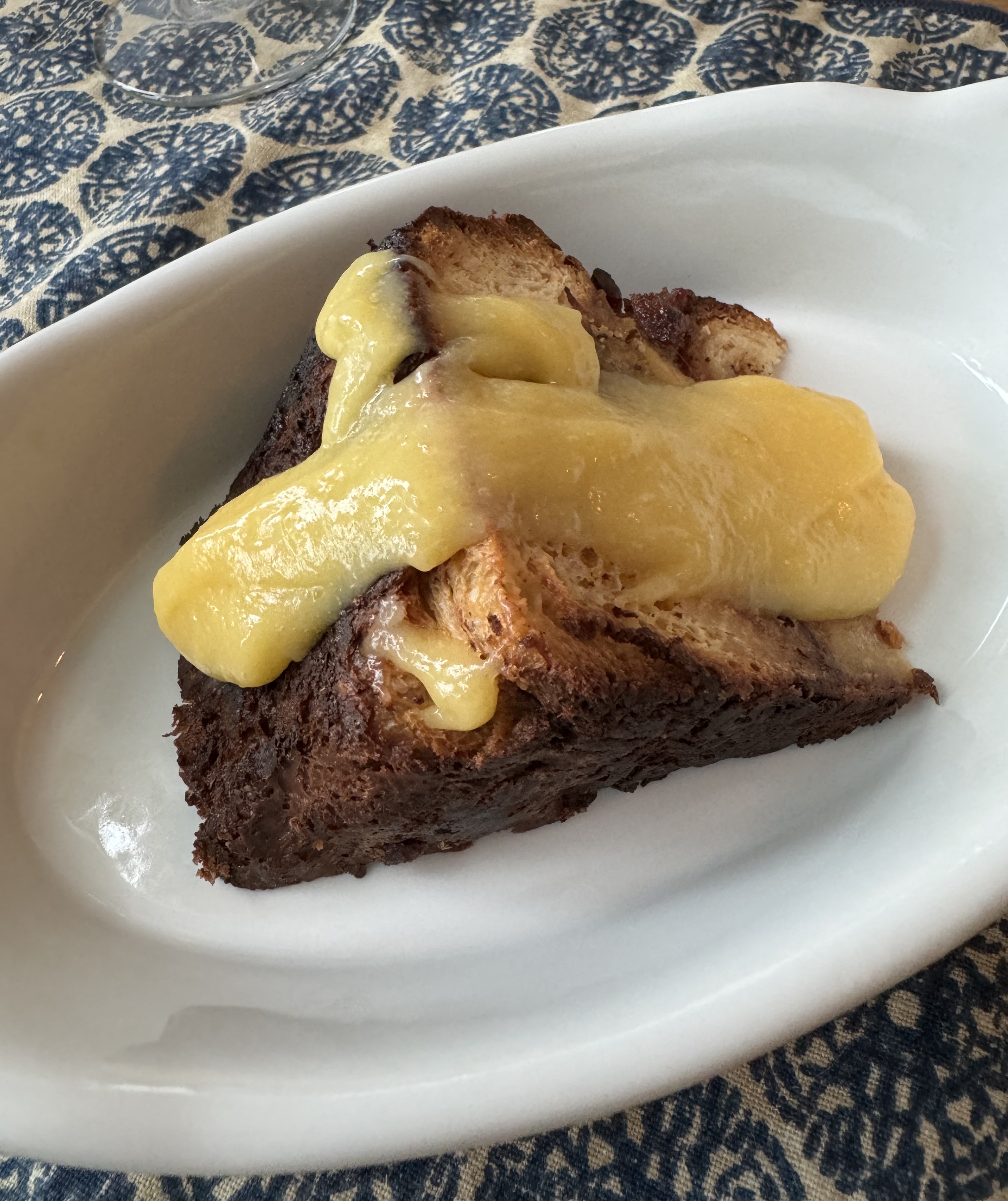 Slice of bread putting, with its crust very, very well-browned. A heavy yellow sauce oozes down the slice.