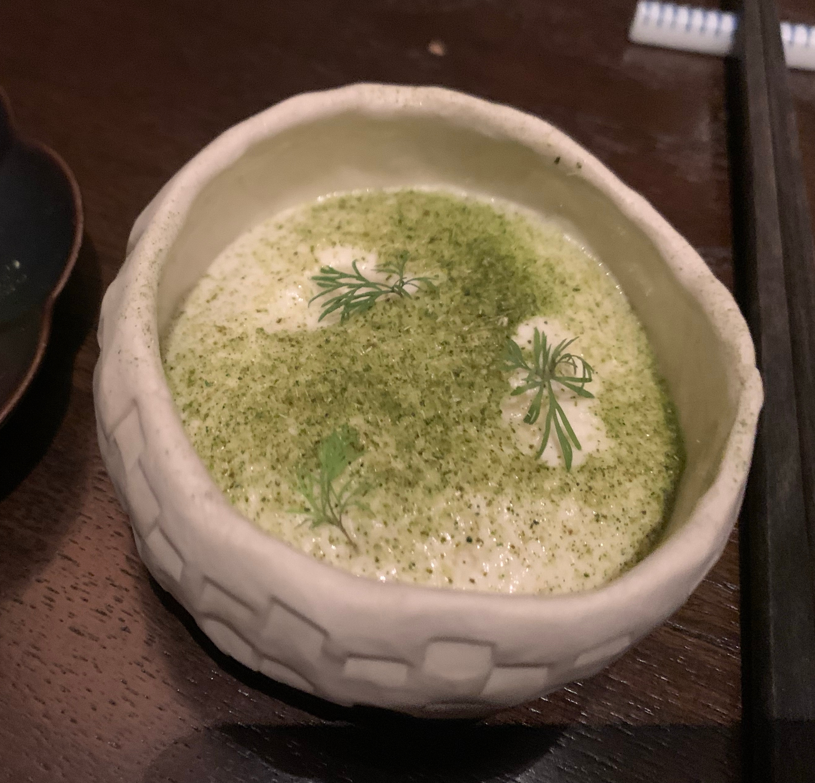 A bowl of foam, with green powder on top. No lobster is visible.