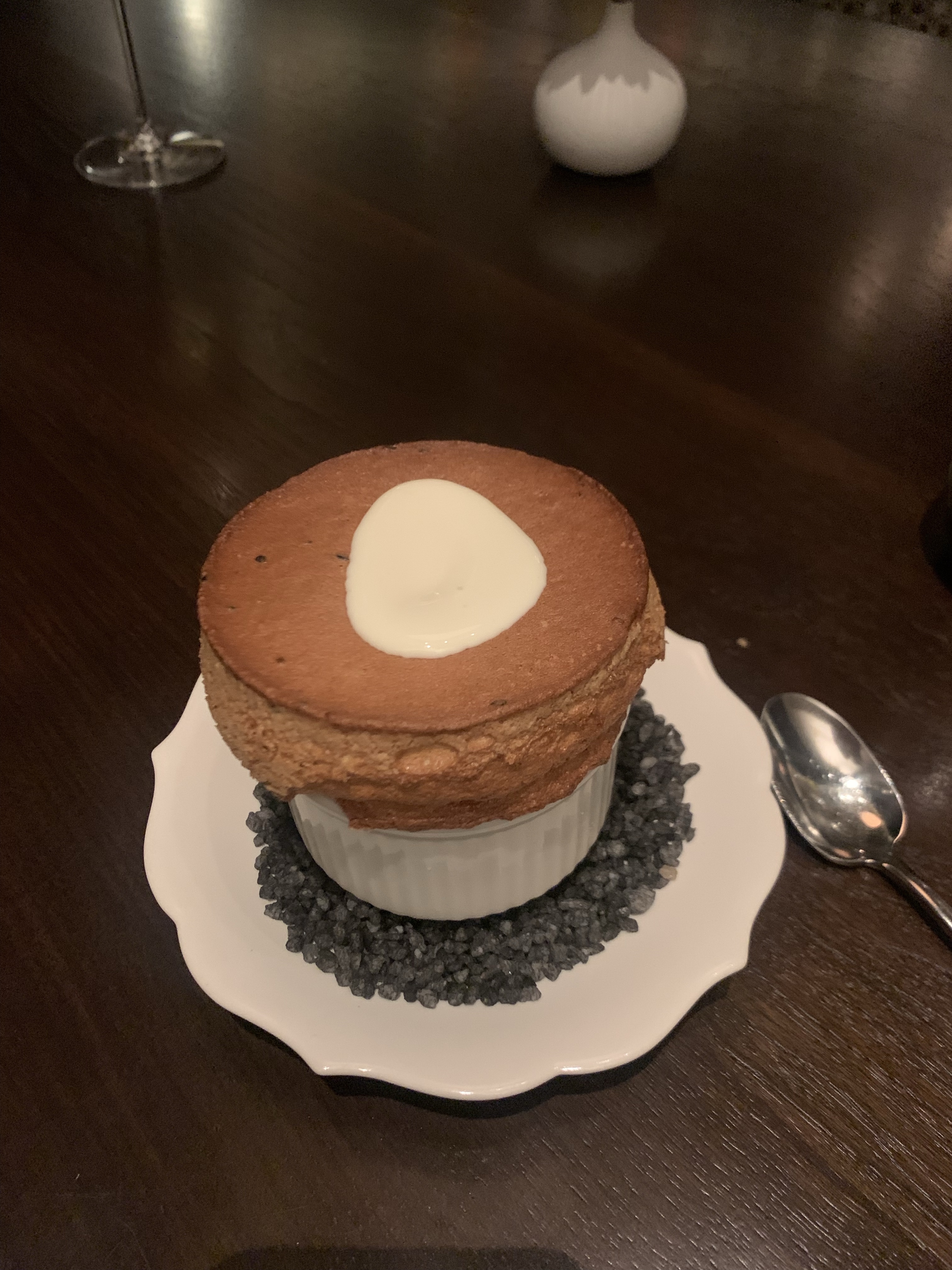 Souffle, with a large golden-brown head coming out of the cup, and some cheese sauce in the middle