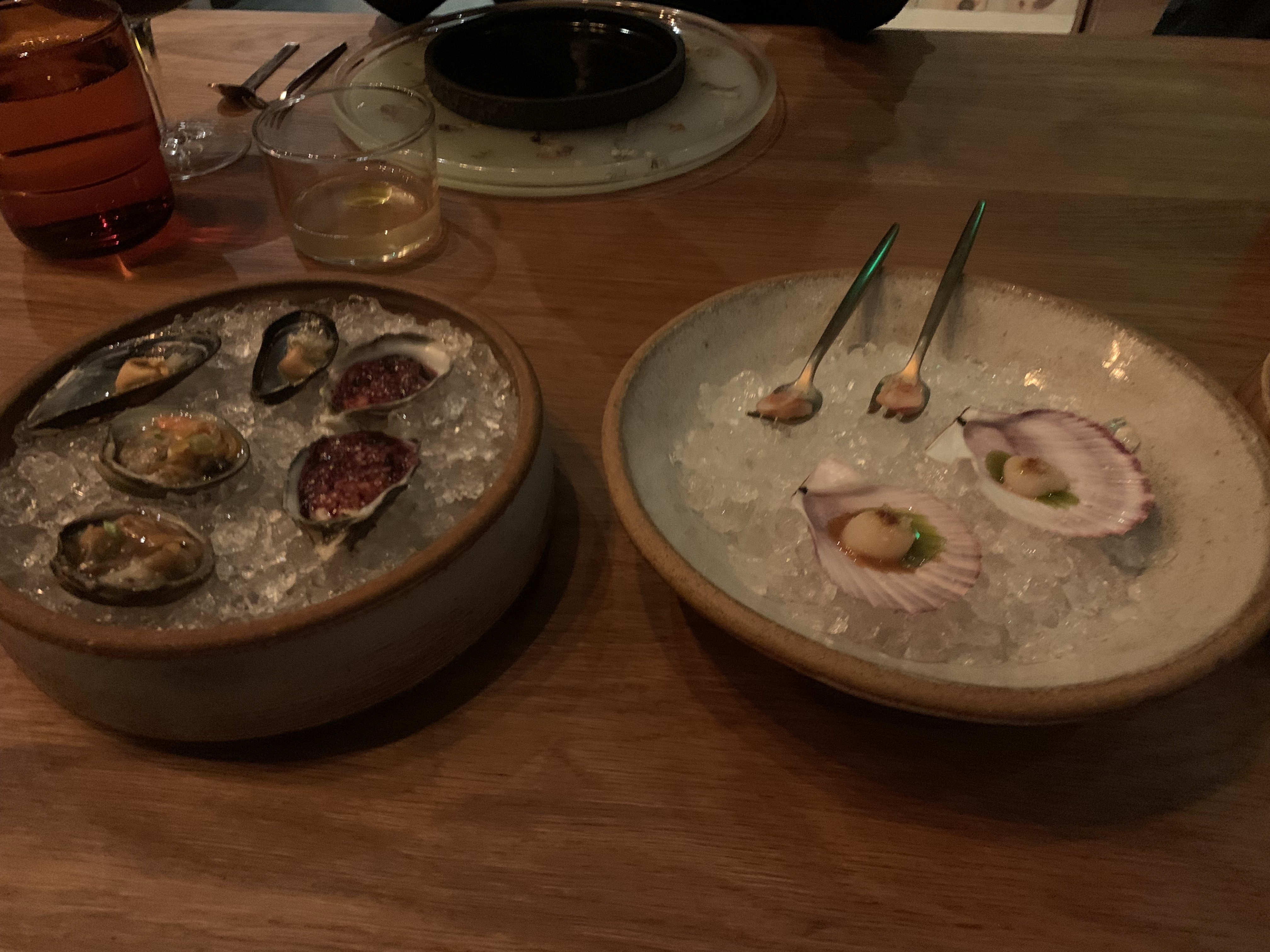 Two plates with various shellfish: mussles, clams, and oysters